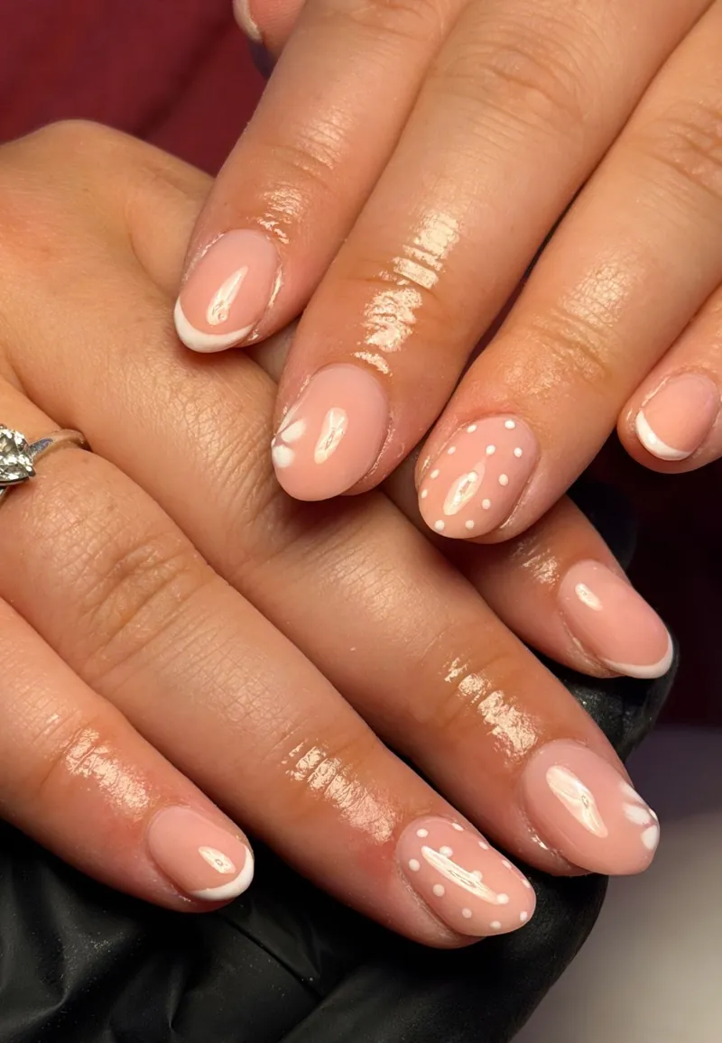Nude nails with white French tips and small white dots, by Rosie Mae Beauty