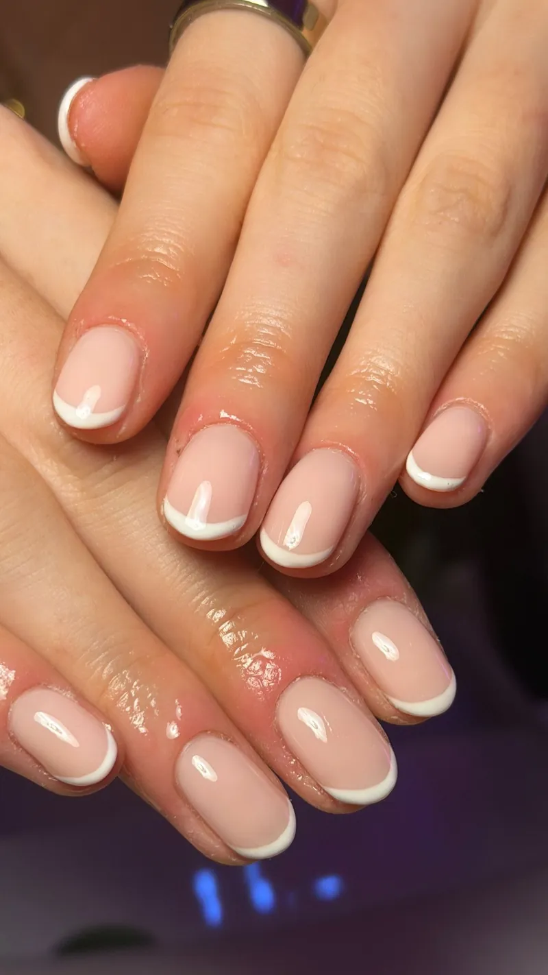 Short nude nails with thin white French tips, by Rosie Mae Beauty